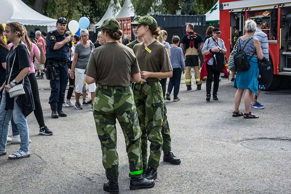 Three soldiers among crowd of people.
